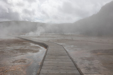 Fototapeta na wymiar Walk the Mystical Path: Explore Yellowstone's Geothermal Wonders on a Foggy Day, Connecting with Nature and Discovering the Beauty of Natural Wonders
