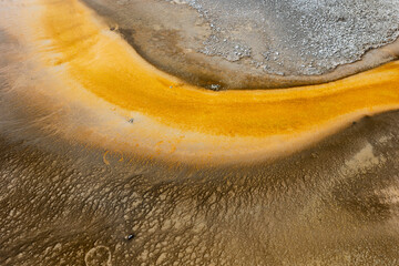Obraz na płótnie Canvas Stunning aerial view of vibrant yellow river winding through textured earth, creating a natural abstract landscape with unique geological formations