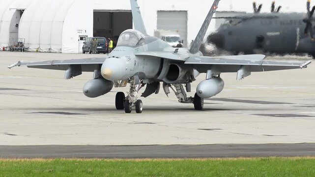 F-18 aircraft prepares for takeoff at the busy airbase during sunrise