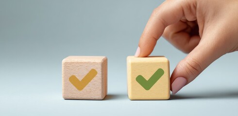 A hand is placing a wooden block with a check mark on it next to another block with a check mark