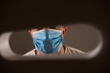 Close-up of medical assistant with face mask looking at camera