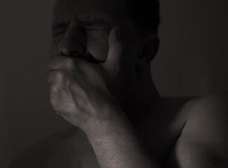 Hopeless disappointed man in dark room interior, selective focus

