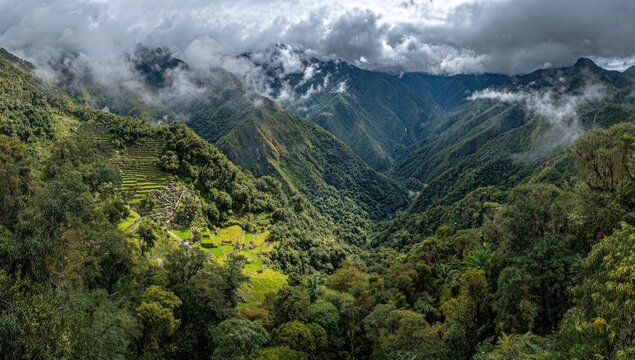 High-angle view of terraced mountain valley, lush greenery, ancient ruins, misty peaks