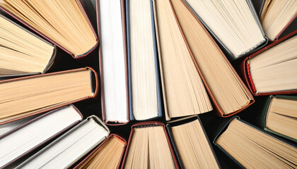 Stack of hardcover books with visible pages and spines arranged in circular pattern, showing variety of paper colors and textures, evoking sense of knowledge and curiosity