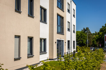 Modern residential building with bright facade and well-maintained landscaping in a sunny urban area