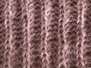 Soft texture study of a fuzzy knit fabric in a gentle pink or mauve color.  Fine, delicate fibers likely from a yarn like mohair or angora.