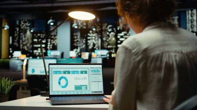 Female finance advisor reviews trading accounts and archived data for future reports, using digital graphs to plan resources allocation and align business goals with financial success. Camera A.