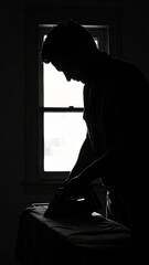 Monochrome silhouette: A man ironing clothes with dramatic lighting and shadows