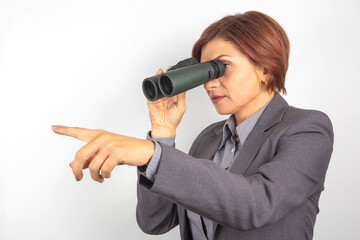 Businesswoman using binoculars to observe distant objects during outdoor expedition