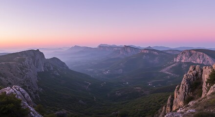 Panoramic view of mountain range at dawn with clear sky and valley