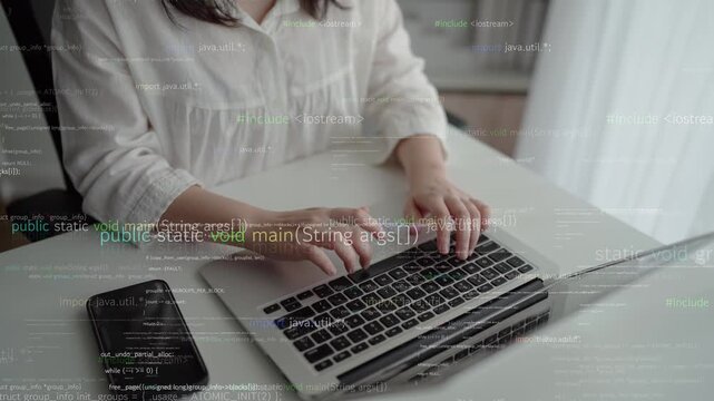 Close-up view of hands typing on a laptop keyboard amidst a backdrop of code, symbolizing remote work, digital innovation, and the world of programming and technology. Xenic