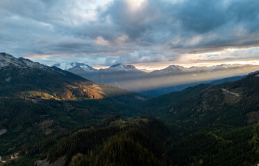 Naklejka premium Sunlit Mountain Valley Over Snow-Capped Peaks at Sunset in British Columbia, Canada