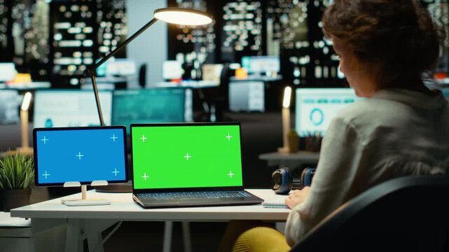 Business consultant works with mockup copy space on tablet and laptop, researching reports for a management project. Collecting information and solving tasks late at night, work after hours. Camera B.