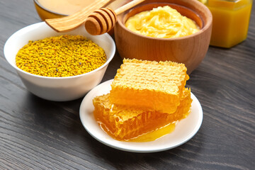 Fresh honeycomb and bee products arranged on a wooden table with natural ingredients