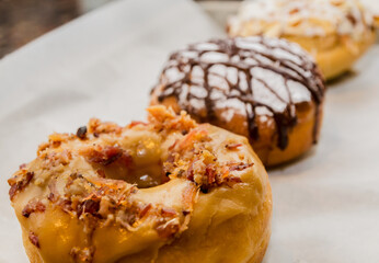 Toasted coconut almond doughnut, salted caramel bacon doughnut, and Nutella-filled cream puff in Decatur Georgia