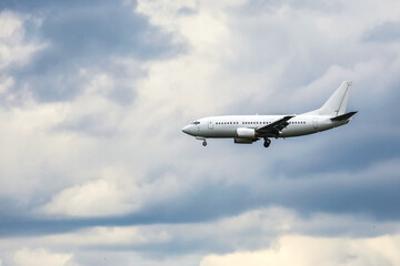 Commercial airplane flying through a cloudy sky during late afternoon