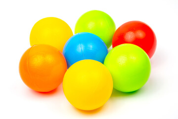 Colorful plastic balls arranged in a playful cluster on a white surface