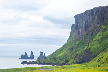 Stunning coastal cliffs and rock formations along the Icelandic shore on a cloudy day