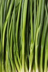 Fresh green spring onions as background, top view