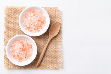 Top view of Himalayan pink salt in bowl with spoon on white background, Healthy food ingredient