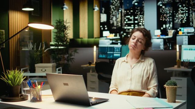 Entrepreneur contemplating on a complex problem in a dark office late at night, strategizing and typing options on laptop. Seeking a logical solution through careful concentration. Camera A.