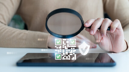 Hand holding a magnifying glass over a digital QR code with security shield and check mark icons, concept of QR verification, data authentication, secure identity, and trusted transaction.