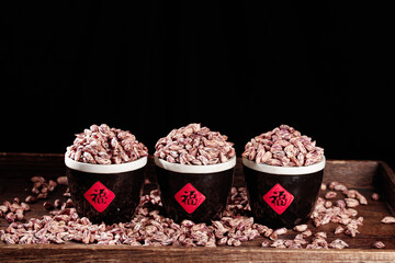 Traditional Chinese bowls filled with colorful speckled beans on wooden table