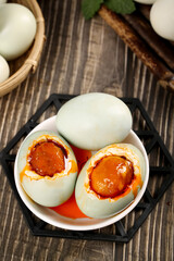 Traditional Chinese Salted Duck Eggs with Golden Yolk Flow on Wooden Background