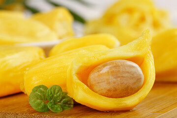 Fresh Thai Mango Slices with Pit and Mint Garnish on Wooden Board