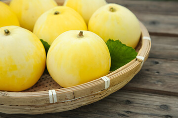 Fresh Yellow Melons in Wicker Basket on Wooden Background - Organic Fruit Harvest