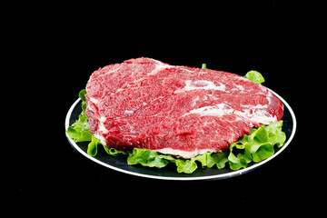 Fresh Raw Beef Brisket Cut on Plate with Lettuce Garnish Ready for Cooking