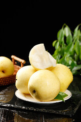Fresh Sweet Crown Pears from Hebei China on Plate with Green Leaves and Rustic Kitchen Setting