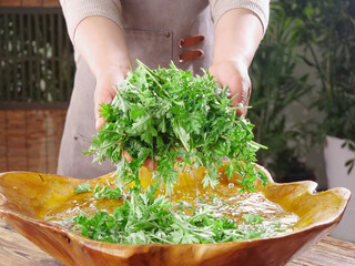 Freshly Picked Large Mugwort Leaves Being Washed in Wooden Bowl for Natural Herbal Cooking