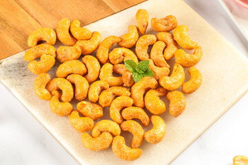 Vietnamese Salt-Baked Crispy Cashew Nuts with Mint Garnish on Wooden Board