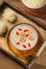 Asian dessert soup with red dates and silver fungus in wooden bowl on bamboo placemat