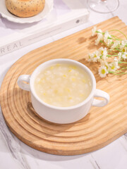 Fresh White Corn Porridge with Kernels in Ceramic Mug on Wooden Serving Tray