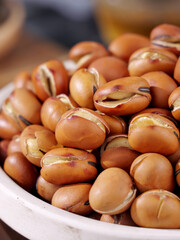 Fried crispy beans in bowl - golden brown legumes with cracked shells for healthy cooking and snacking