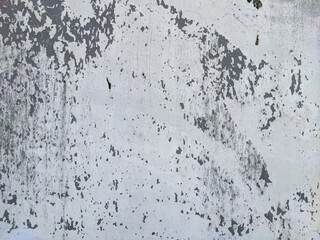 A rustic, weathered wall, featuring a textured surface with peeling light-colored paint and exposed patches of a darker, gray substrate. The grunge aesthetic suggests age and natural decay.