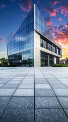 Modern glass building at sunset, reflecting vibrant sky