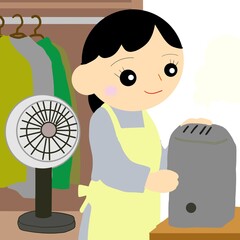 扇風機をしまい、加湿器を出す主婦
