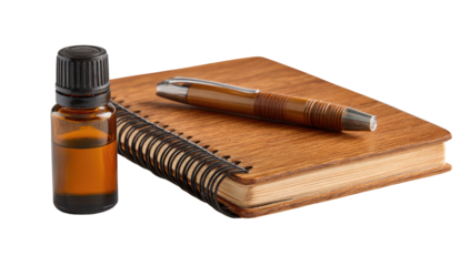 A spiral-bound notebook rests beside a small amber glass bottle.  A brown pen lies on the book