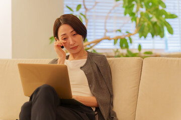 夜パソコンで仕事する眼精疲労の女性