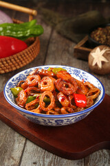 Chinese Dry-Fried Pork Sausage Dish with Peppers in Traditional Blue White Porcelain Bowl