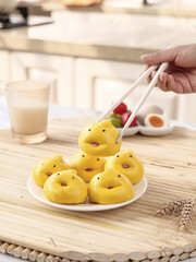Adorable Yellow Cartoon Character Steamed Buns with Chopsticks in Kitchen