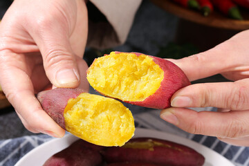 Fresh Cooked Sweet Potato Halves with Golden Yellow Flesh Held in Hands