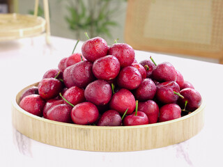 Fresh Red Cherries with Water Drops in Wooden Bowl on Marble Counter
