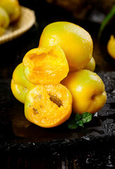 Fresh Dunhuang Apricots Cut in Half Showing Juicy Flesh on Dark Slate Surface