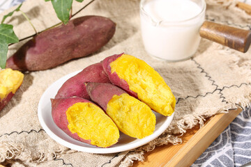 Purple Sweet Potatoes with Yellow Flesh on Rustic Wooden Table with Milk Glass