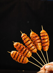Glazed Spiral Sausage Skewers - Traditional Asian Street Food Snacks on Wooden Sticks