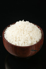 Cooked White Rice in Wooden Bowl on Black Background - Healthy Grain Food Ingredient